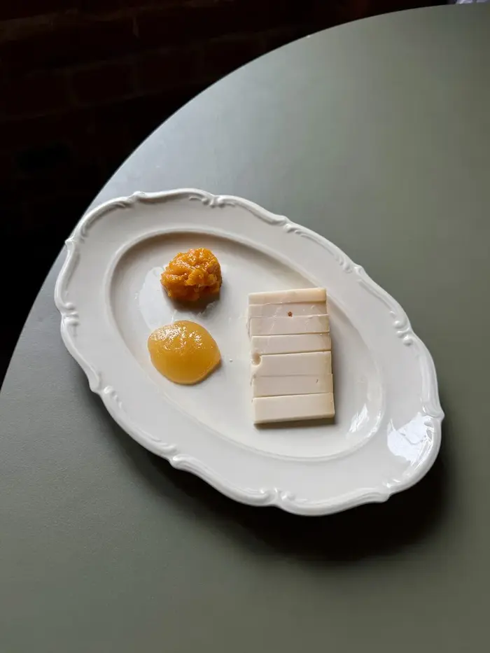 Deser z gruszką w winie i lodami na ciemnym talerzu w Pijalnych