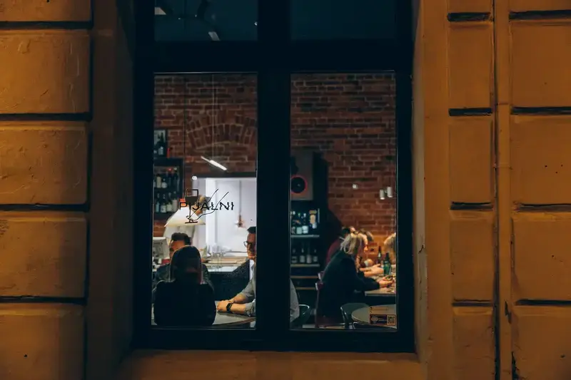 Widok na Pijalni wieczorem — ciepłe światło z wnętrza restauracji