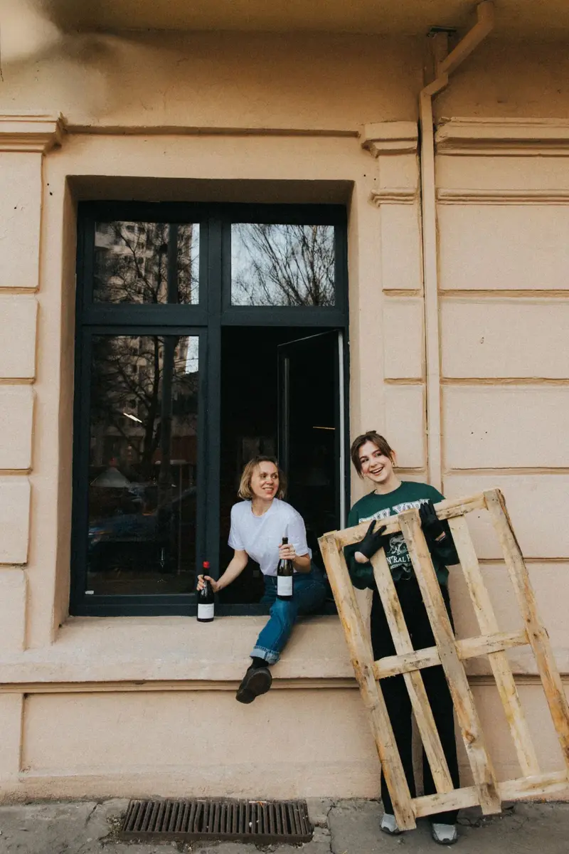 Pijalni team gathered by the restaurant window in natural daylight