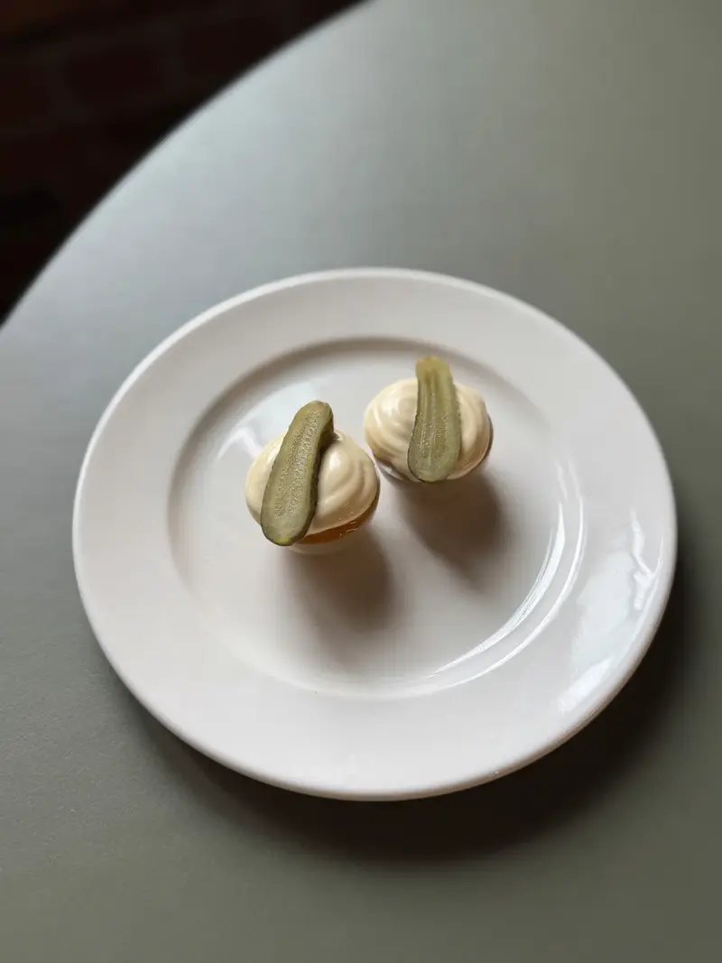 Zwei kleine Matcha-Baiser auf einem weißen Teller im Pijalni